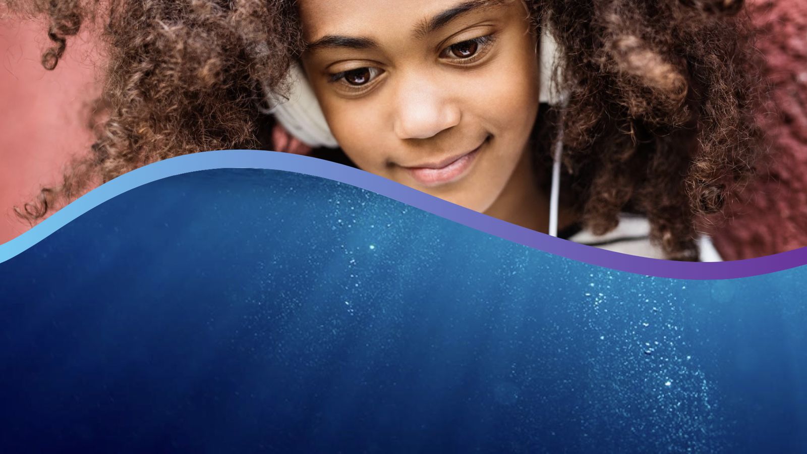 A student wearing headphones looks down at the water